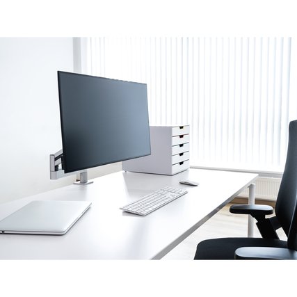 Monitorarm mit Bildschirm an einem modernen Schreibtisch, Laptop und Tastatur sichtbar.