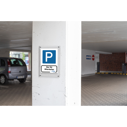 Schild mit einem blauen Parkplatzsymbol und dem Text "Nur für Mitarbeiter" in einer Garage.
