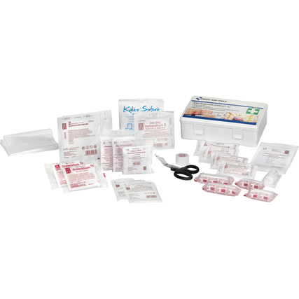 Erste Hilfe Koffer mit verschiedenen Verbänden, Pflastern und Zubehör auf einem Tisch ausgebreitet.