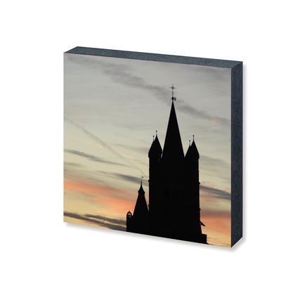 Dekobild in Form eines Fotoquadrats mit Silhouette einer Kirche vor pastellfarbenem Himmel.