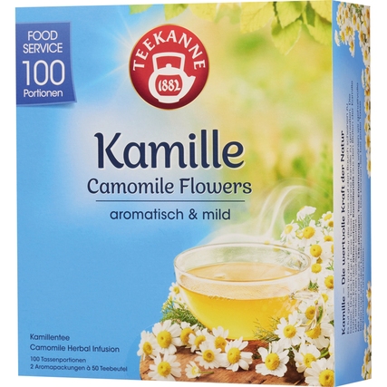 Packung mit Teekannen-Tee Kamille und einer Tasse, umgeben von Kamillenblüten.