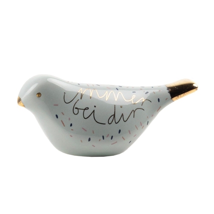 Dekorationsfigur in Form eines Vogels mit der Aufschrift "Immer bei dir" und goldenen Akzenten.