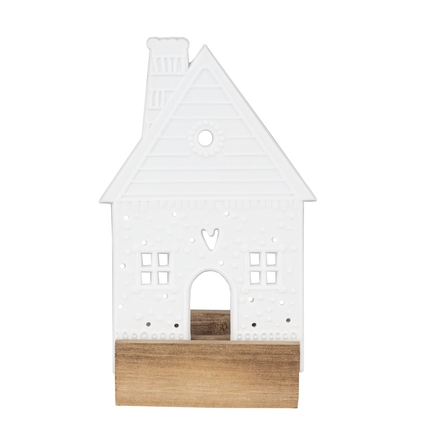 Teelichthalter in Form eines weißen Lebkuchenhauses mit Holzsockel.