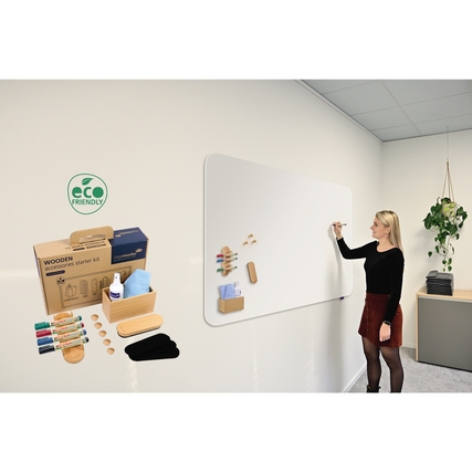 Frauenfigur schreibt an einem Whiteboard, daneben das Legamaster Starterset WOODEN und Zubehör.