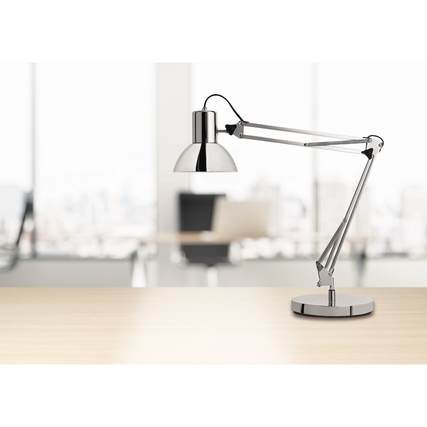 Tischleuchte mit verchromtem Lampenschirm und drehbarem Arm auf einem hellen Tisch in Büroraum.
