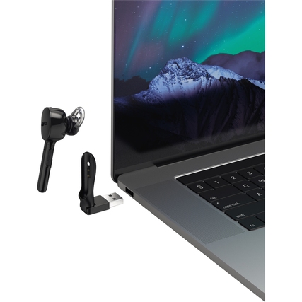 Bluetooth-Mono-Headset in Ear-Form neben USB-Ladestation neben einem Laptop.