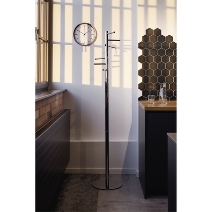 Design-Standgarderobe in Metallic-Look in einem modernen Raum mit Uhr und hexagonalem Wandmuster.