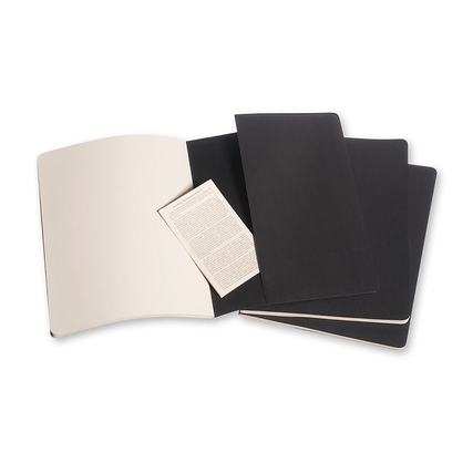 Drei schwarze Cahier-Notizhefte und ein beige einzeln liegendes Blattpapier.