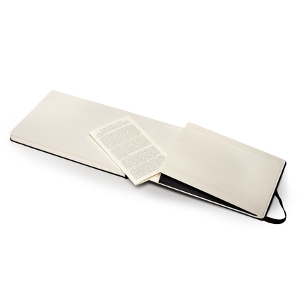 Offenes Aquarellbuch mit beige farbenen Seiten und Innentasche im Hintergrund.