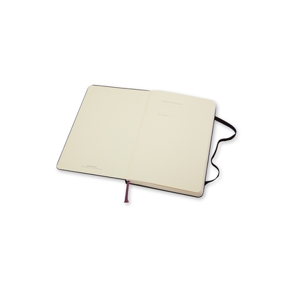 Schwarzes Hardcover-Notizbuch mit leeren Seiten und Lesezeichen, geöffnet auf zwei Seiten.