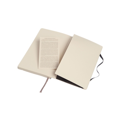 Offenes Moleskine Notizbuch mit einer beige Innenseite und einer herausnehmbaren Informationseite.