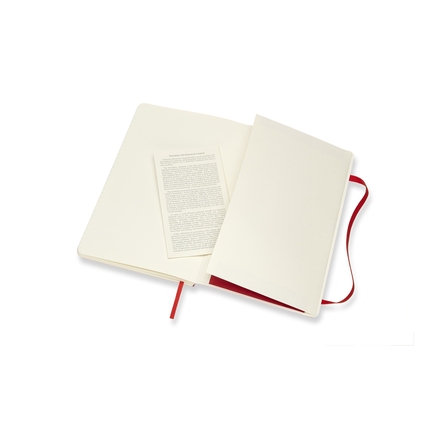 Offenes scharlachrotes Moleskine Notizbuch mit Innentasche und Informationsblatt.