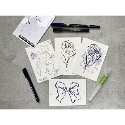 Ein Arrangement von Zeichnungen mit Blumenmotiven und verschiedenen Stiften auf einem Tisch.
