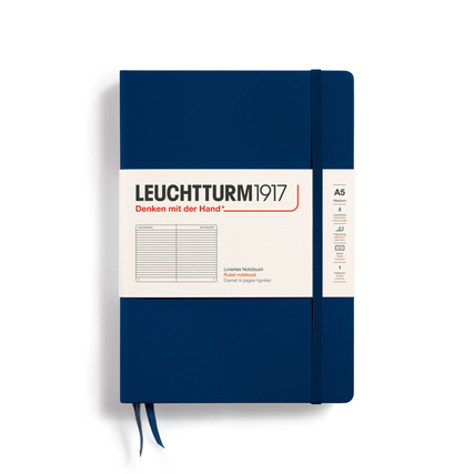 Blaues Notizbuch im DIN A5 Format mit liniertem Papier und einem weißen Umschlagetikett.