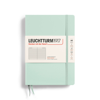 Mintgrünes Notizbuch im A5-Format mit Umschlag und gummierter Bindung.