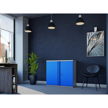 Blauer Flügeltürenschrank in einem modern gestalteten Büro mit Pflanzen und Möbeln.