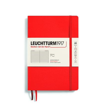 Rotes Notizbuch im DIN A5 Format mit Softcover und Gummiband, linierte Seiten sichtbar.