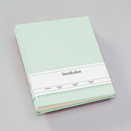 Mintgrünes Fotoalbum mit gerade Rückenflügeln und einem weißen Schriftband umwickelt.