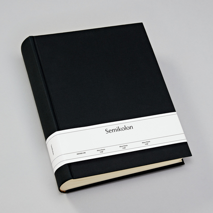 Schwarzes Fotoalbum aus Buchleinen mit einem weißen Etikett in der Mitte.