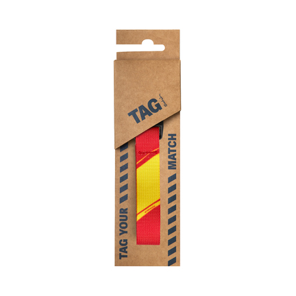 Rotes und gelbes Rucksack-Accessoire im Karton mit dem Schriftzug "TAG YOUR MATCH".