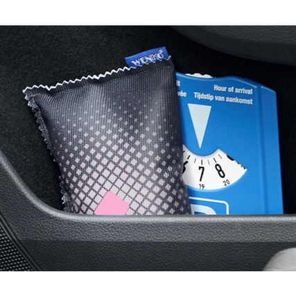 Luftentfeuchter in einer Auto-Innenablage, neben einem blauen Temperaturindikator.
