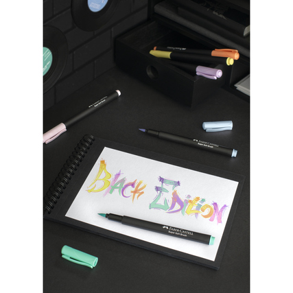 Pinselstifte in Pastellfarben auf einem Notizblock mit dem Text "Black Edition".