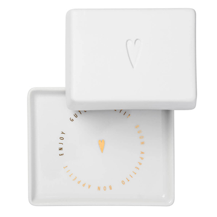 Weiße Butterdose in Herzform mit goldenem Schriftzug und einem Herzsymbol auf dem Deckel.