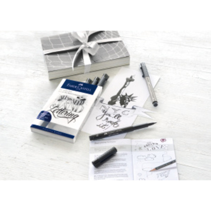 Tuschestift-Set mit Hand Lettering Booklet, Stiften und Dekoration auf einem Tisch.