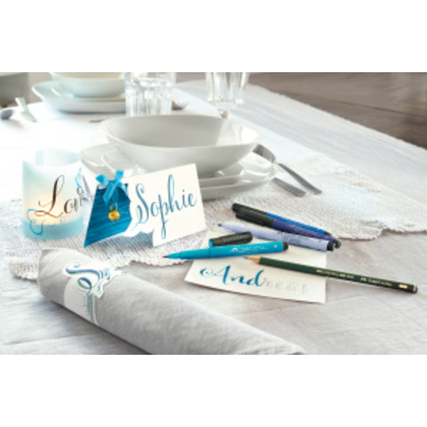Tischgedeck mit Handlettering-Karten und Faber-Castell Tuschestiften auf einem Tisch.