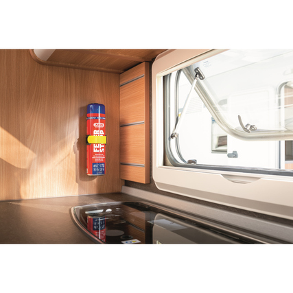 Feuerlöschspray in einer Küchenumgebung, an einer Wandhalterung neben einem Fenster montiert.