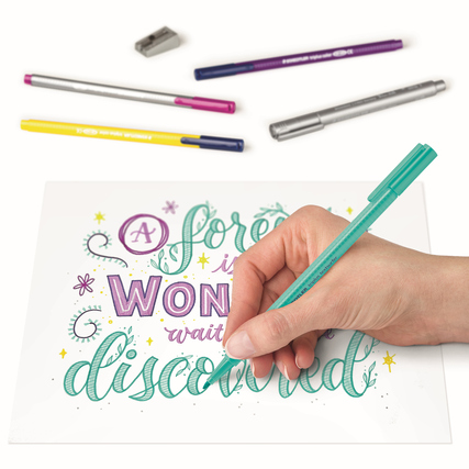 Hand, die mit einem grünen Stift auf einem beschrifteten Papier für Hand Lettering arbeitet.