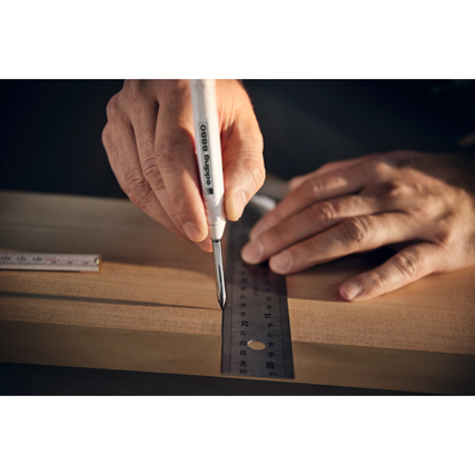 Tieflochmarker wird in der Hand genutzt, um eine Markierung auf einem Holzstück zu setzen.