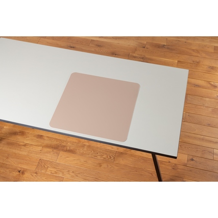 Schreibunterlage in soft rose auf einem grauen Tisch, umgeben von Holzfußboden.