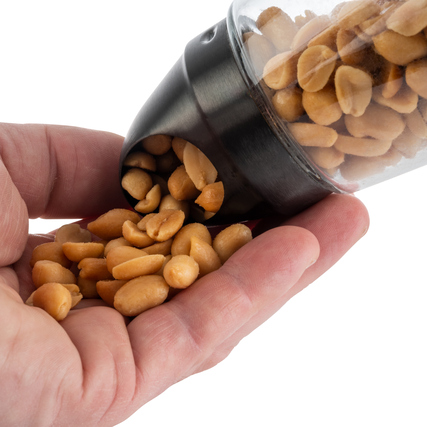 Snackspender mit Erdnüssen, der in einer Hand gehalten wird, mit herausfließendem Inhalt.