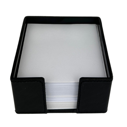 Schwarze Zettelbox mit offenem Deckel, gefüllt mit weißen Blättern.