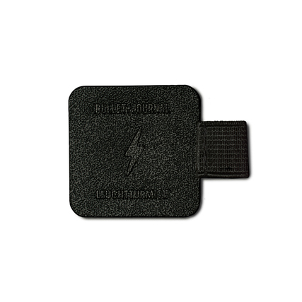 Schwarzes, quadratisches Deckblatt eines Notizbuchs mit Reliefschrift und Gummiband.