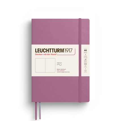Notizbuch im Format A5 mit Softcover in Dusty Rose, geschlossen mit Gummiband und Lesezeichen.