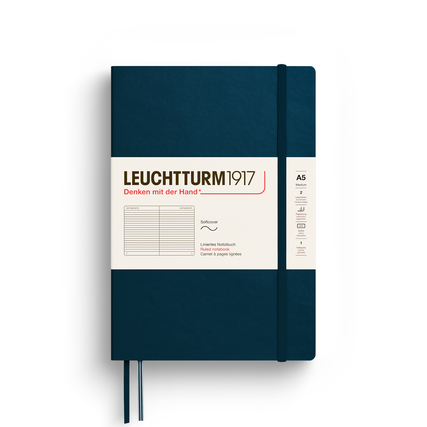 Notizbuch in tiefblauem Softcover mit Gummiband und beschrifteter Vorderseite, DIN A5.