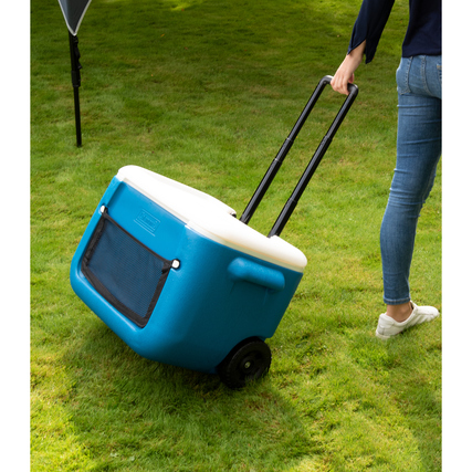 Wheeled Kühlbox in Blau mit ausziehbarem Griff, im Einsatz auf grünem Gras.