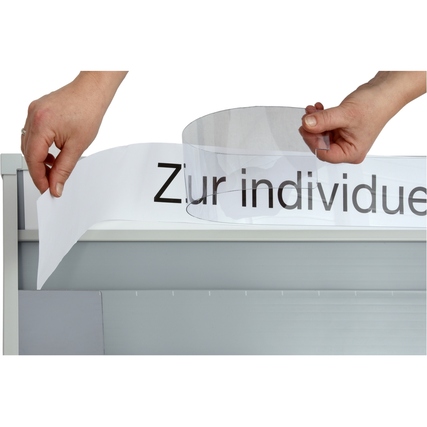 Hände platzieren ein beschriftbares Blatt auf der Oberkante einer Kartentafel.