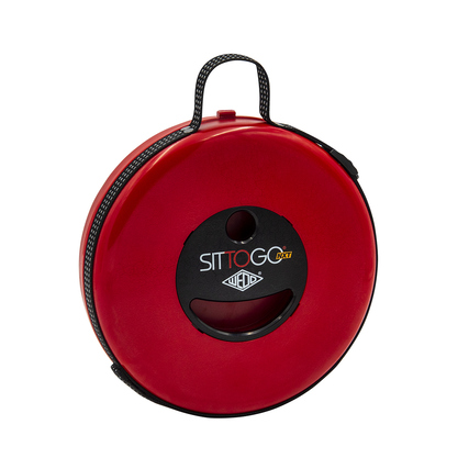 Runder, roter Sitzhocker SITTOGO® NXT mit Tragegriff in komprimierter Form.