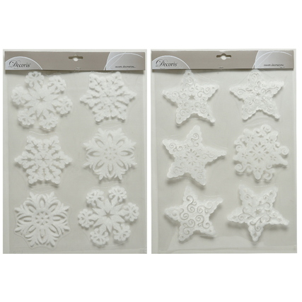 Zwei Packungen mit jeweils vier weißen Fensterbildern in Form von Sternen und Schneeflocken.