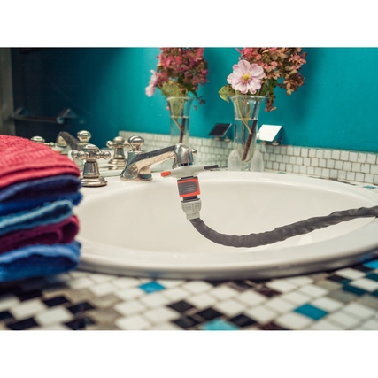 GARDENA Gartenbrause an einem Wasserhahn in einer Badezimmerumgebung mit Handtüchern.