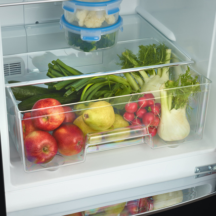 Kühlschrank mit Obst und Gemüse in durchsichtigen Fächern, zusätzlich Dekoration oben.