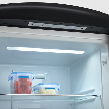 Innenansicht der Kühl-Gefrierkombination mit LED-Beleuchtung und Lebensmittelbehältern.