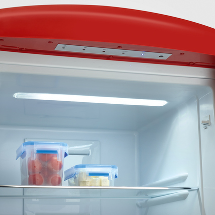 Innensicht einer roten Kühl-Gefrierkombination mit LED-Beleuchtung und Vorratsbehältern.