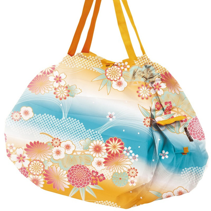 Bunte Shupatto Tragetasche mit floralem Design in blauen, gelben und rosa Farbtönen.