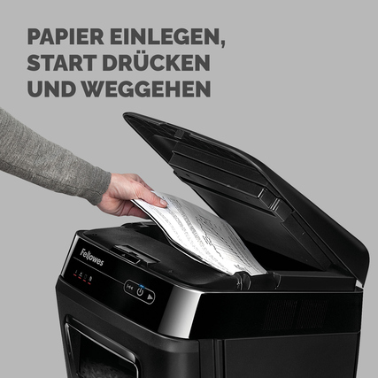 Person legt Papier in den Aktenvernichter Fellowes® AutoMax™ 200M und drückt den Startknopf.
