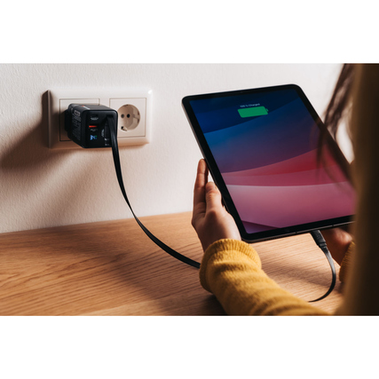 Verbatim GaN 65 W Ladegerät in Steckdose mit Tablet, das aufgeladen wird.