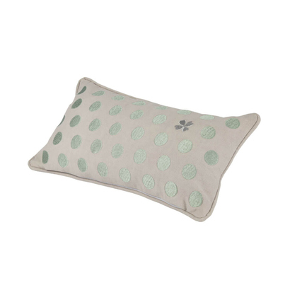Rechteckiges Kissen in beige mit grünen Punkten und einer blauen Stickerei in der Mitte.